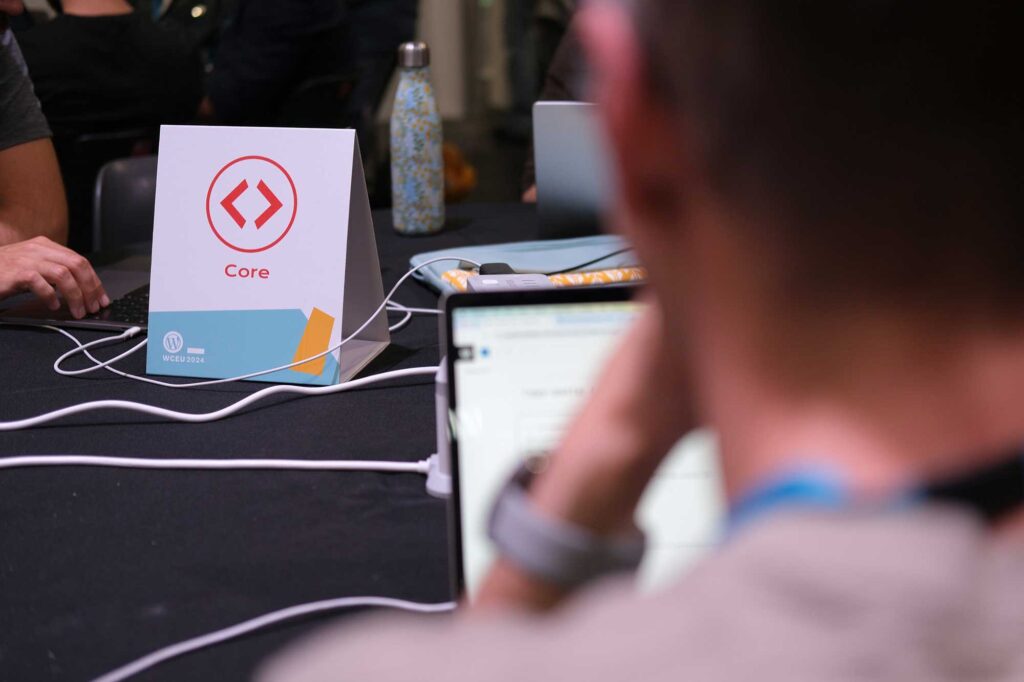 A sign that says "Core" sitting on a table, and blurred in the foreground is the back of a person's head.